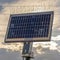 Square Solar panel with thin wires against scenic sky with white and gray clouds