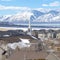 Square Spire of church towering over homes in the valley overlooking snowy mountain