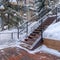 Square Stairs and wooden deck on snowy hill with decorative and colorful string lights