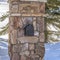 Square Stone post with mailbox and outdoor lamp against sunlit snow in Park City Utah