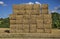 Square straw bales under a blue sky