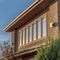 Square Sunlit house exterior with view of the upper storey against mountain and sky