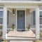 Square Symmetrical house facade with vinyl wood siding and gray front door