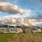 Square Tall brown grasses with stylish homes and snow capped mountain in the background