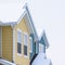 Square Townhome exterior with snowy gable valley roof against overcast sky in winter