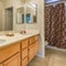 Square Vanity with double sink and wood cabinets inside the small bathroom of a home