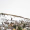 Square Vast cloudy sky over houses built on a hill blanketed with fresh snow in winter