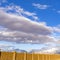 Square Vibrant blue sky with puffy clouds over a lake and grand snow capped mountain