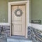 Square Vintage porch table and chair of house with front door decorated with wreath