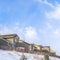 Square Wasatch Mountain residential area with homes against clouds and blue sky