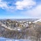 Square Wasatch Mountains in winter with homes on a neighborhood amid nature scenery