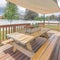 Square Whispy white clouds Deck of a house with wooden chairs and table under a shade sail