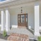 Square Whispy white clouds Exterior of a house with bricks doorsteps and detached garage