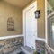 Square White door and window with blinds at home facade with concrete and stone wall