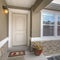 Square White front door and reflective window of a home against road and cloudy sky