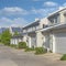 Square White puffy clouds Attached garages of townhouses with concrete driveway at Daybrea