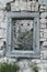 Square window in a stony wall of old ruins in Slovenia