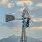 Square Windpump with a snow covered mountain and cloudy blue sky in the background