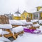 Square Winter in Daybreak with view of a purple sled in the middle of wooden chairs