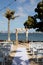 Square wooden wedding arch for outdoor beach yacht club wedding. White chairs and decorated arch for destination waterfront