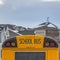 Square Yellow school bus with rectangular window and several signal lights at the rear