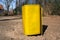 Square yellow trash can in the park