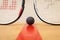 Squash ball between two squash rackets