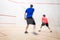 Squash players in action on a squash court