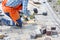 A squatting worker lays paving slabs with a rubber mallet