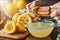 Squeezing fresh lemon juice with wooden reamer into bowl