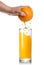 Squeezing orange juice pouring into glass isolated