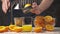 Squeezing an orange with a manual press, close view, making a glass of fresh. Fresh oranges on a wooden table, whole and sliced.
