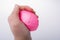 Squeezing pink balloon with hand