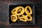 Squid rings in breadcrumbs pack, on old dark  wooden table background, top view flat lay