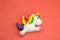 squishy unicorn toy on a coral background