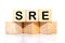 SRE. Site Reliability Engineering inscription on wooden cubes on a white background