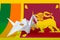 Sri Lanka flag depicted on paper origami crane wing. Handmade arts concept