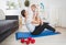 SSim mother playing with her baby on fitness mat at home