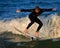 St. Augustine, FL - FEb 17 - Surfer rides the waves at sunset in St Augustine, FL