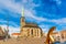 St. Bartholomew`s Cathedral in the main square of Plzen with a fountain on the foreground against blue sky and clouds sunny day.