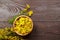 St. Johnâ€™s wort Hypericum perforatum petals in wooden bowl on brown table. Medicinal plant with yellow flowers, healing herb