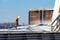 St. Louis, Missouri, USA, December 2020 - Deckhand hoses corn grain off barge deck cover after loading on Mississippi River