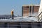 St. Louis, Missouri, USA, December 2020 - Deckhand hoses corn grain off barge deck cover after loading on Mississippi River