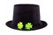 St Patrick black hat decorated with a pair of green clovers holiday symbol lies on an isolated background design