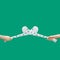 St Patrick minimal concept. Man hands hold criss-crossed two hurly sticks â€“ hurleys in white color with shamrock decoration.