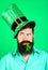 St. Patrick\'s Day. Bearded man in leprechaun hat. Portrait of pensive man. Clover in mouth. Bearded leprechaun. Happy Irish