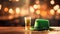 St. Patrick's Day celebration concept - glass with cold green Irish beer drink, empty wooden tabletop, golden bokeh