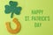 St.Patrick `s Day. celebration. Golden horseshoe and clover leaf on a bright green background. top view