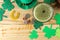 St.Patrick `s Day. celebration. green leprechaun hat and green beer, bow tie, coins and clover on a natural wooden background. to
