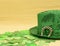 St. Patrick's Day concept. Green clover mockup, shamrock on yellow background and green hat with wooden decorative